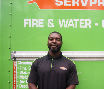 SERVPRO employee pictured in front of green background