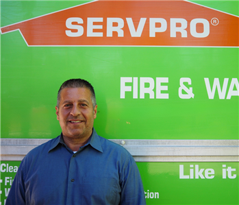 SERVPRO employee pictured in front of green background